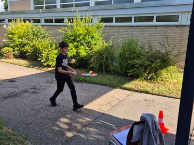 Ein Schüler balanciert einen Ball auf einem Tennisschläger