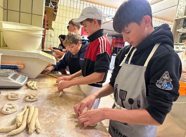 Schüler formen ganz konzentriert Brezen