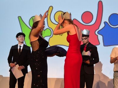Schüler erhalten witzige Kronen aus Pappe mit Aufschriften wie Pausenclown