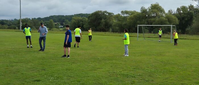 Herr Baderschneider zusammen mit einem Teil der Mannschaften auf dem Rasen vor dem Tor
