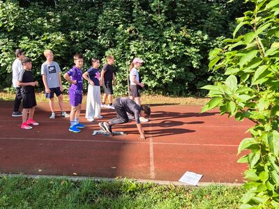 Eine Gruppe von Schülern steht auf der Laufbahn am Start