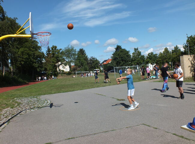 Ein Schüler wirft einen Ball in Richtung Basketballkorb
